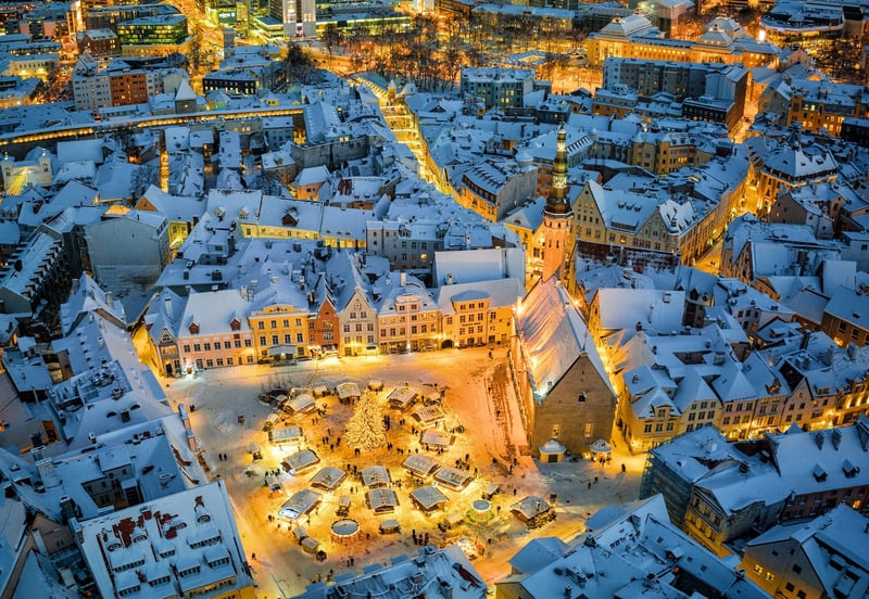 an aerial view of a snowy Tallin Chistmas market at night