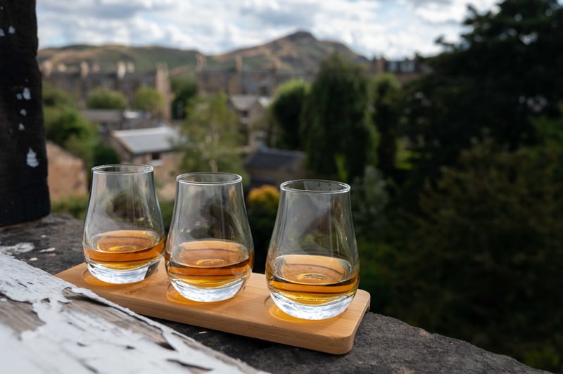 Three whiskey glasses lined up overlooking a quaint Scottish village 