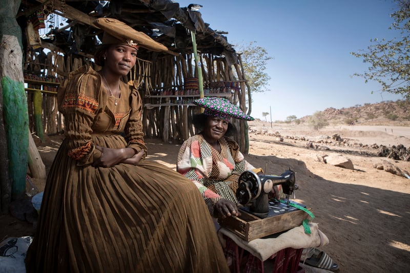 Two women with a sewing machine from a tribe in the Namibian Desert