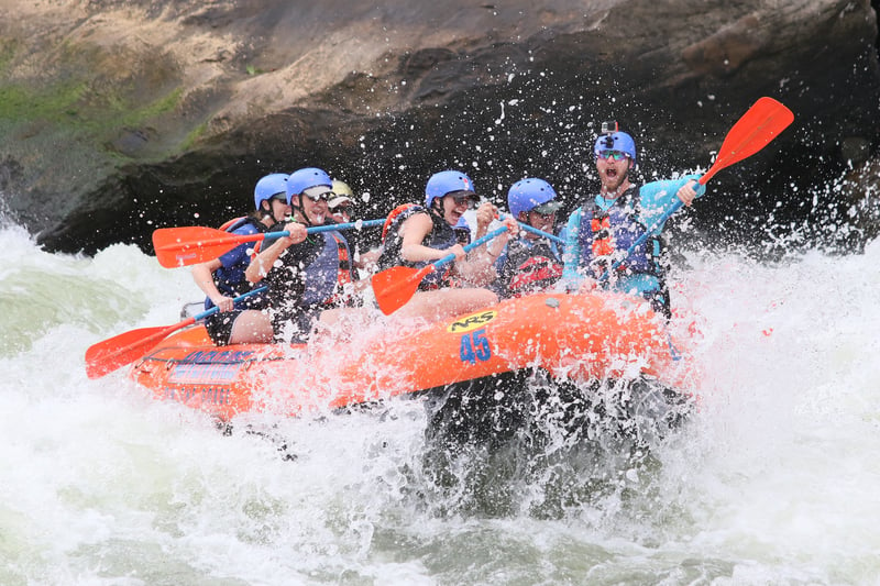 A tour group having fun white water rafting, a popularity adventure activity for experiential travel