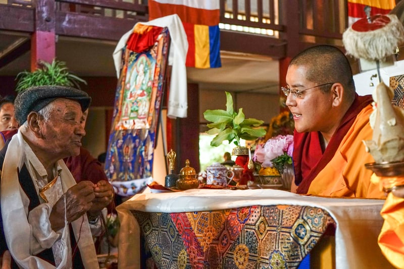 A Nepalese monk consulting an elderly man in colorful surroundings