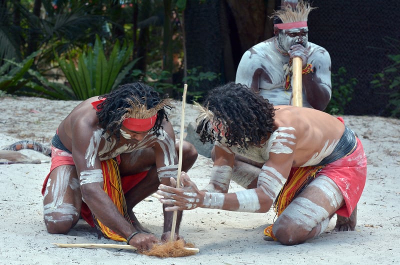 Group of Yugambeh Aboriginal warriors men demonstrate fire making craft during Aboriginal culture show in Queensland, Australia