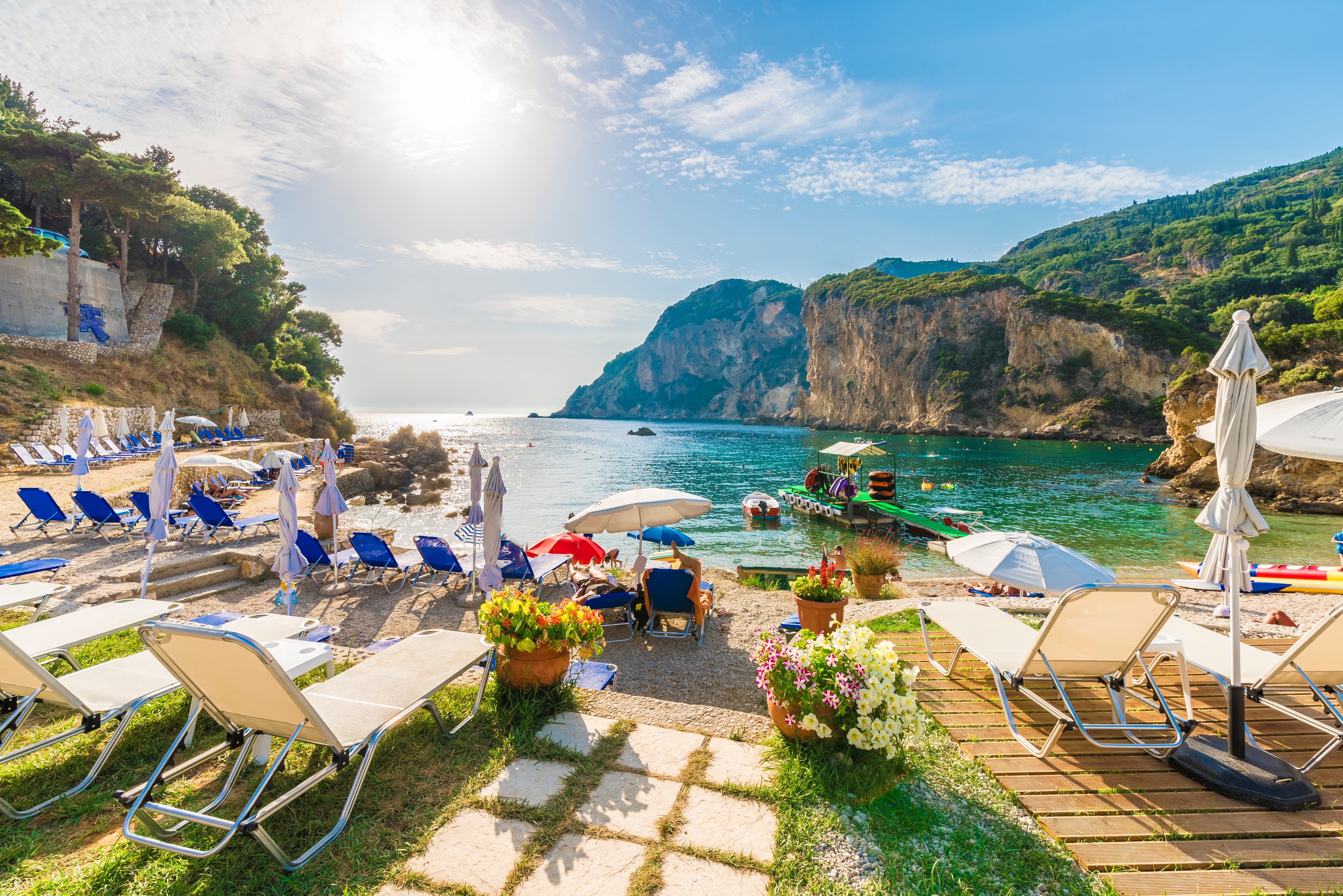 Travel lifestyle: Corfu Mediterranean pebble beach with deck chairs
