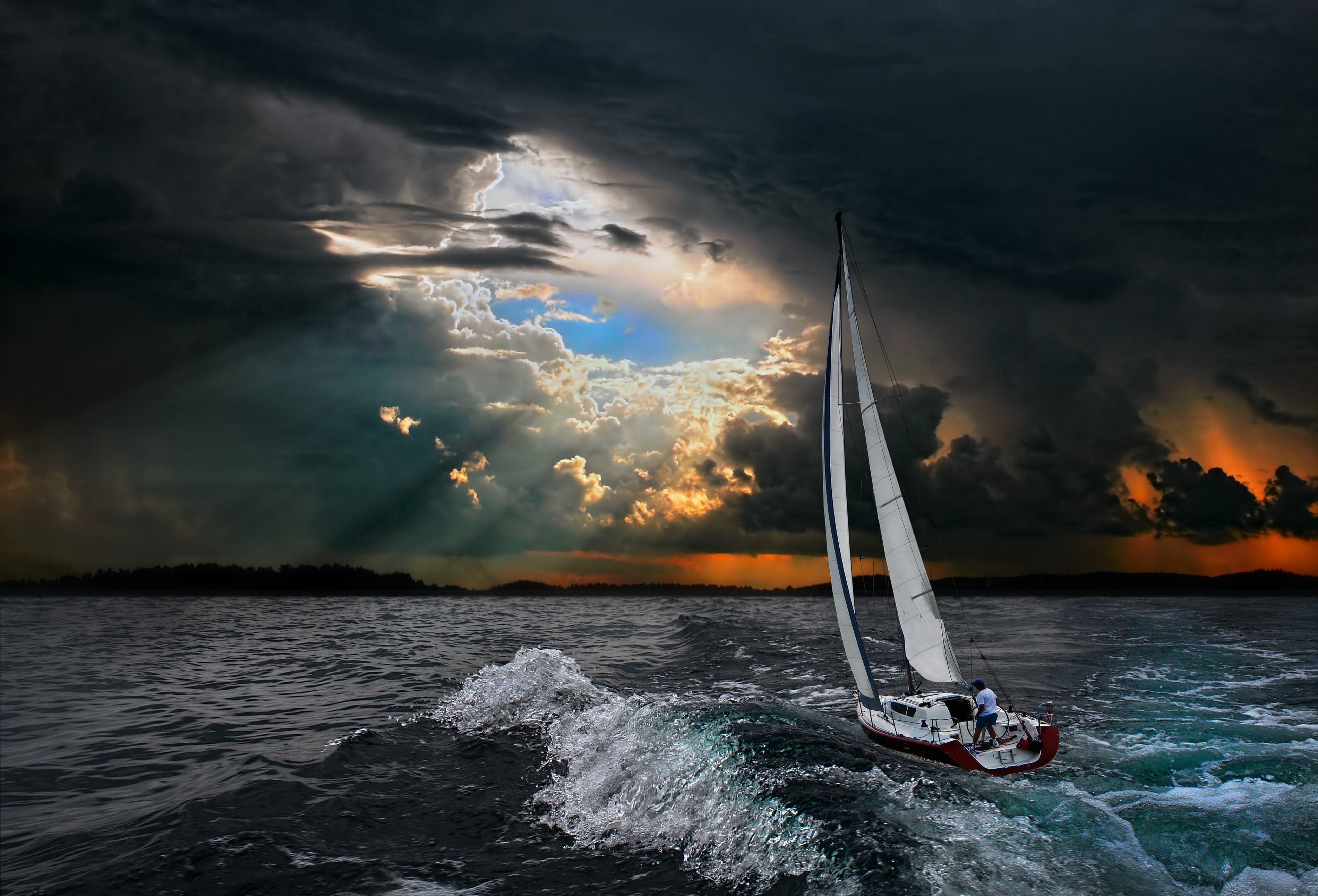 Global travel: Yacht sailing out of storm towards ray of sunshine