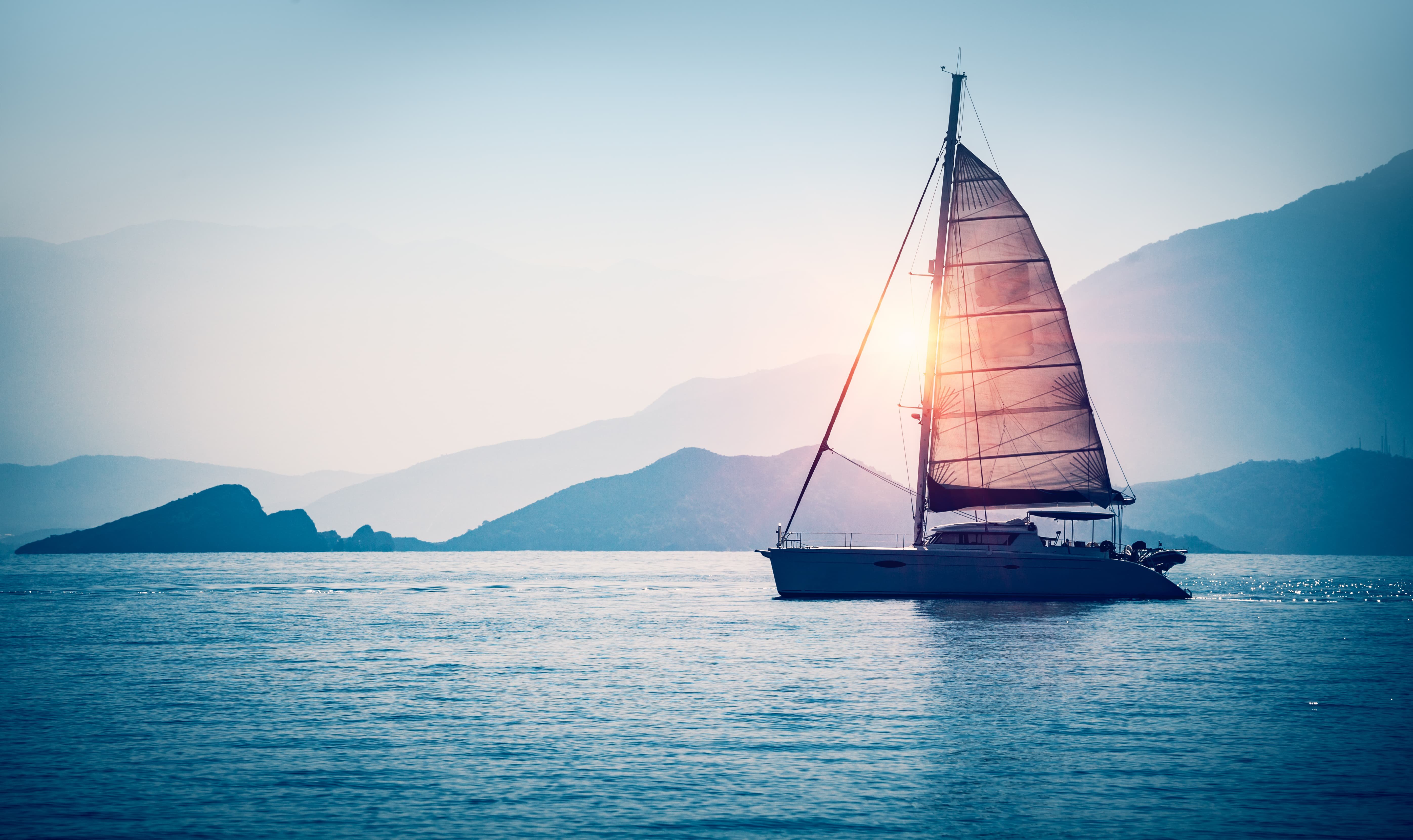 Catamaran sailing at sunset, perfect for yacht life