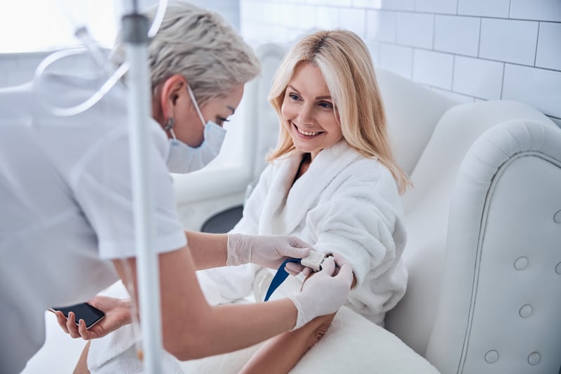 A middle aged blond lady receiving IV therapy for wellness IV treatment for Wellness.Clinic