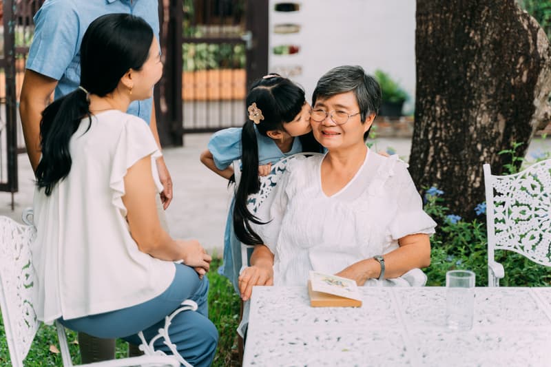 Japanese generational family a key to longevity, grand daughter kissing her grandma on the cheek