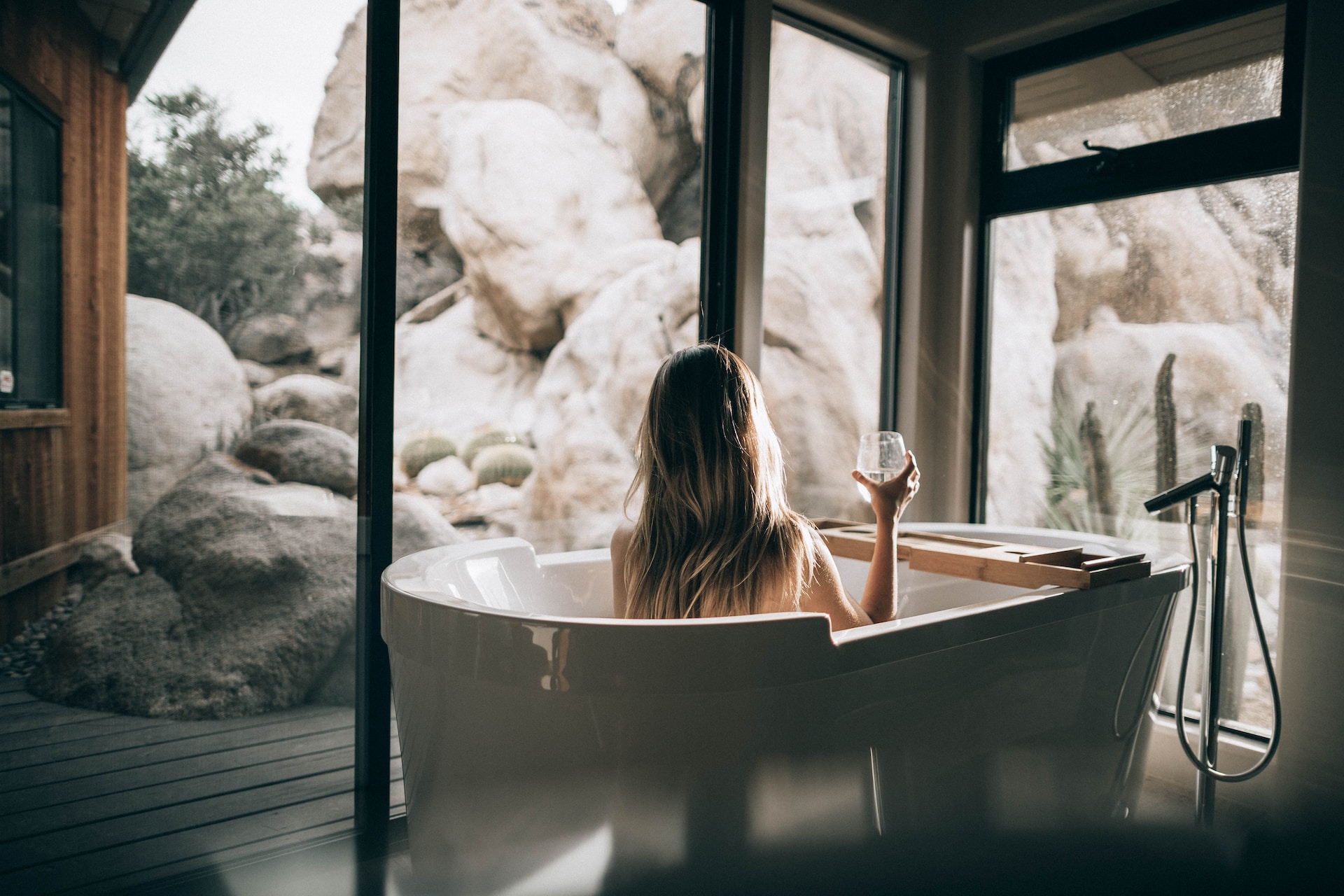 Woman relaxing with a glass of wine in a bath inside a luxury  wellness resort