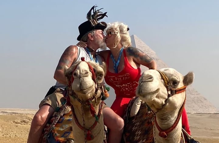 Kiss on camels with pyramid in the background