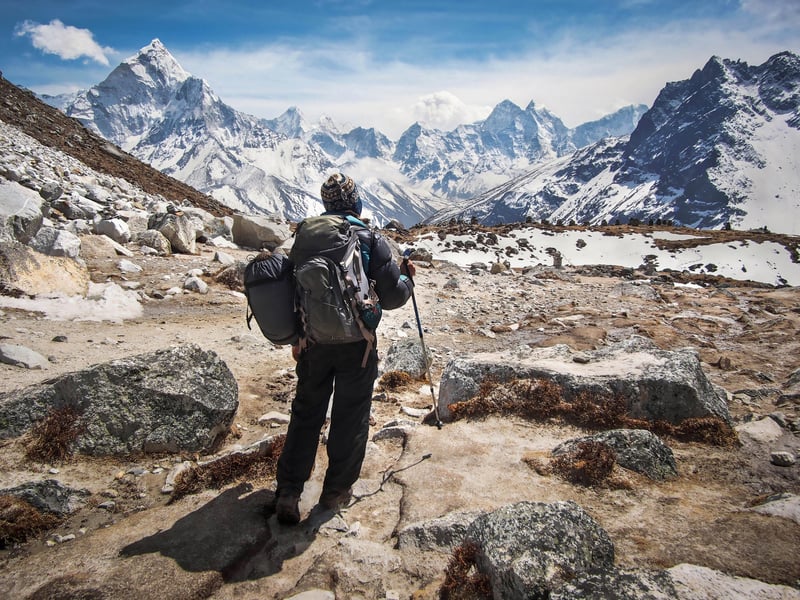 Trekker on the trail to Everest Base Camp with Ama Dablam and other Himalayan peaks in the background, Everest Region, Nepal.