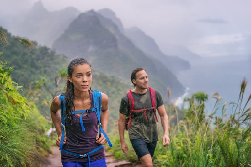 Young good looking couple hiking in one of the world's most scenic national parks, Nāpali Coast State Wilderness Park in Hawaii