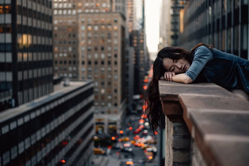 A woman resting her head on a balcony in New Year from exhaustion while on business trip
