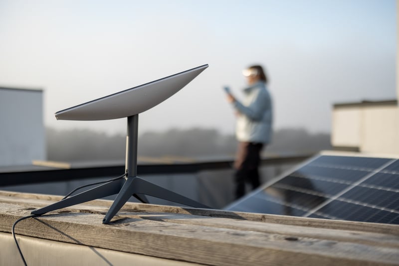 Starlink satellite dish on roof of residential building and woman on background, Starlink could change the game for cruise ship satelitte internet 