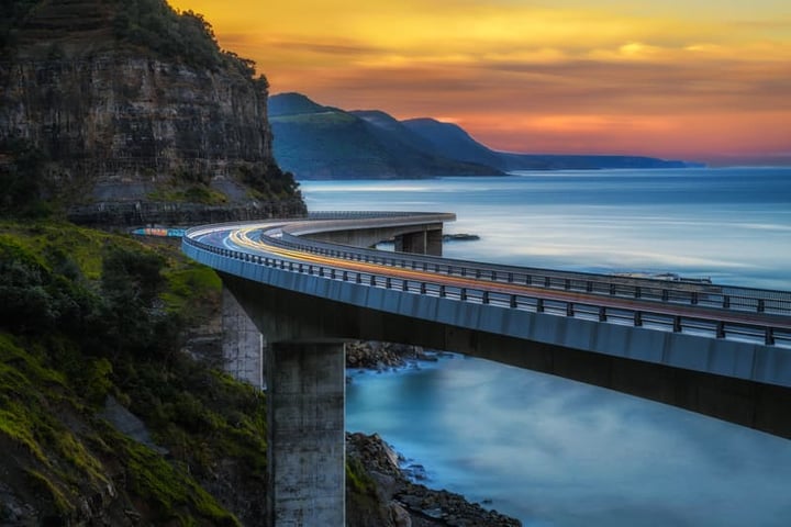 Sunset over the Sea cliff bridge along Australian Pacific ocean, one of the best road trips in the world