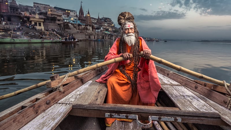 Man rowing boat on river in Varanasi, India.