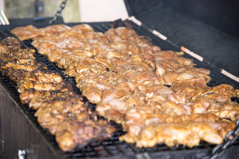 Spicy Grilled Jerk Chicken on the barbecue - style of cooking native to Jamaica - Food Street Market