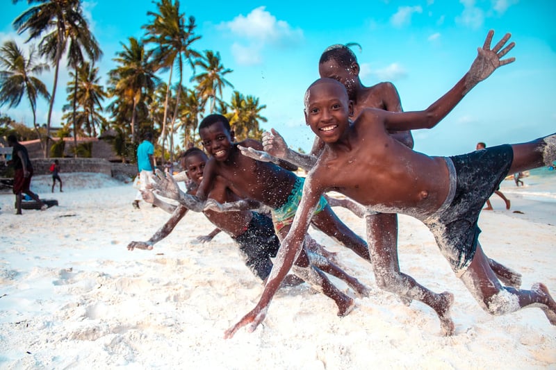 Grateful African kids playing on beach in Kenya, a popular destination for volunteer tourism
