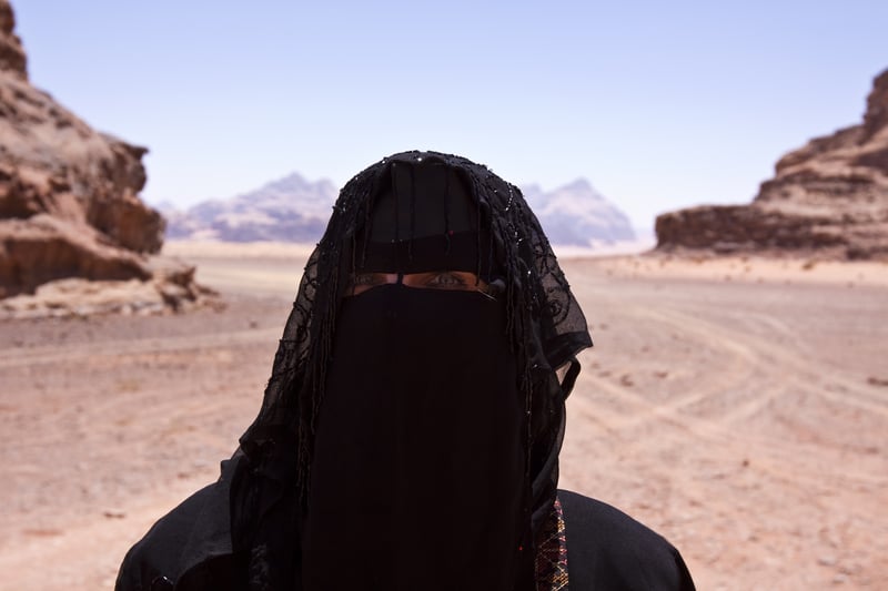 Volunteer empowering Bedouin woman with burka in desert