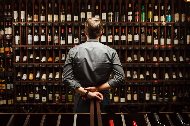 A sommelier in front of different wine variations.