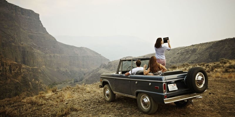 Group of 3 friends stopping their road trip to admire the view.